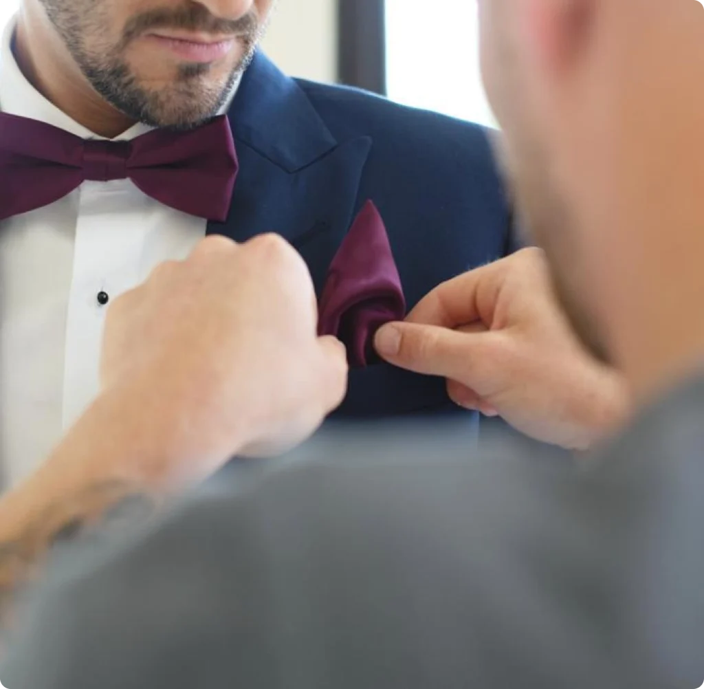 Photo de l'essayage du costume d'un marié avant le mariage avec le témoins qui l'aide