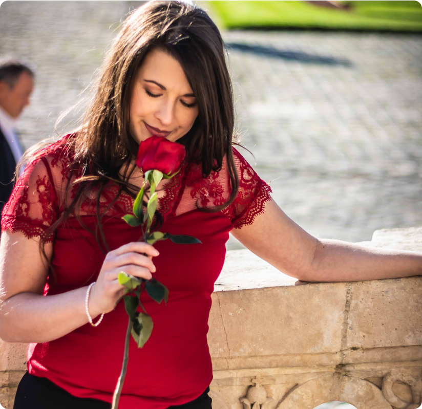 Aurélie Costa, jeune femme, sent une rose rouge symbole de l'Amour